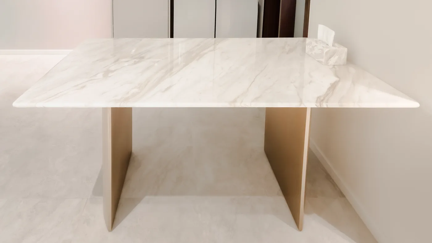 A Calacatta Beige rectangular table on flat gold panel legs